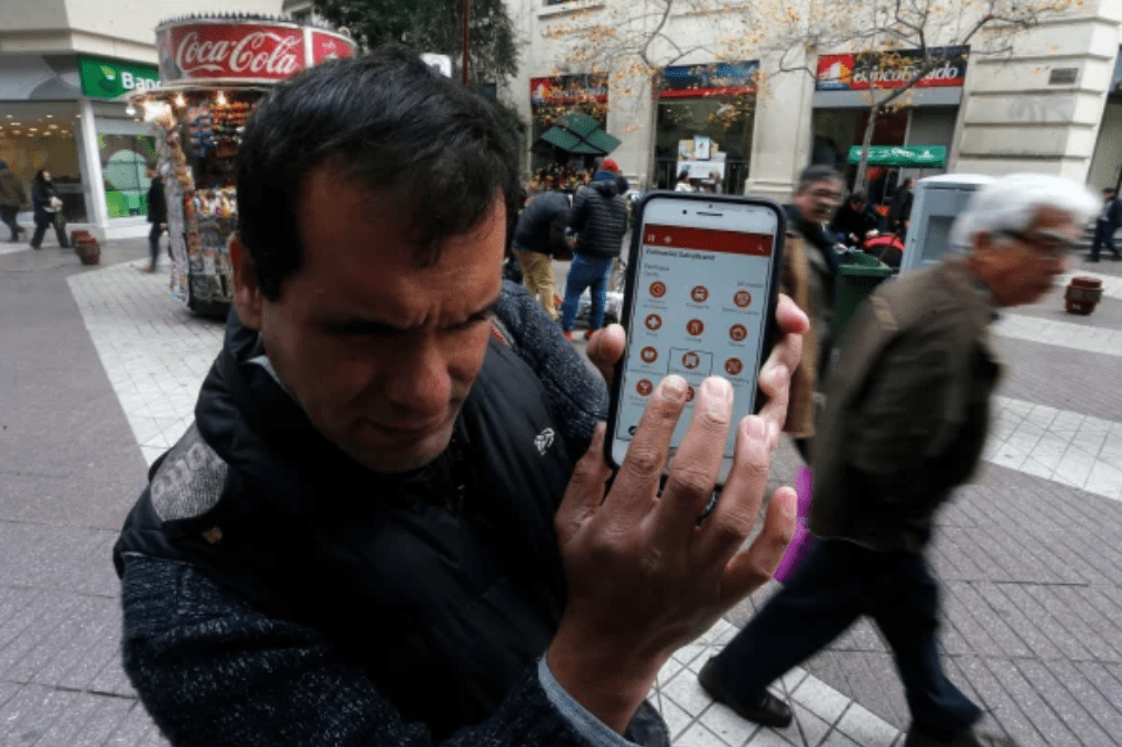 Screen Shot 2021-05-25 at 3.54.38 PM A man uses the Lazarillo app in a crowded plaza