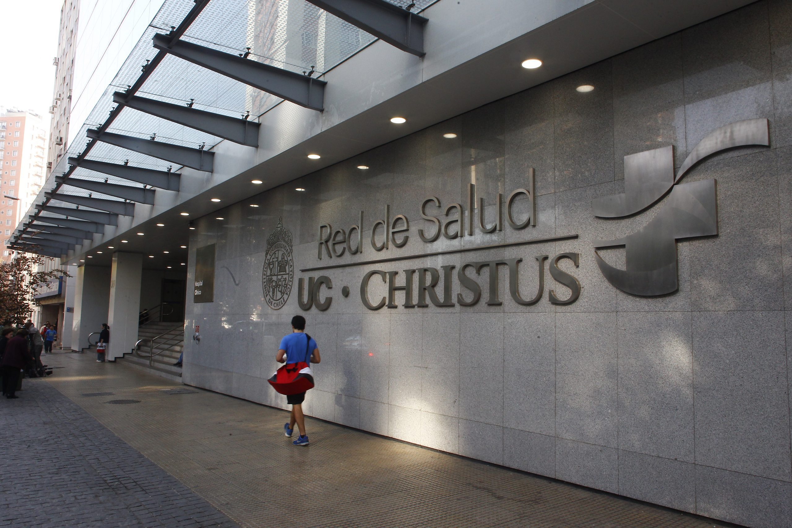 A photo of a man walking outside of the Red de Salud UC Christus facilities.