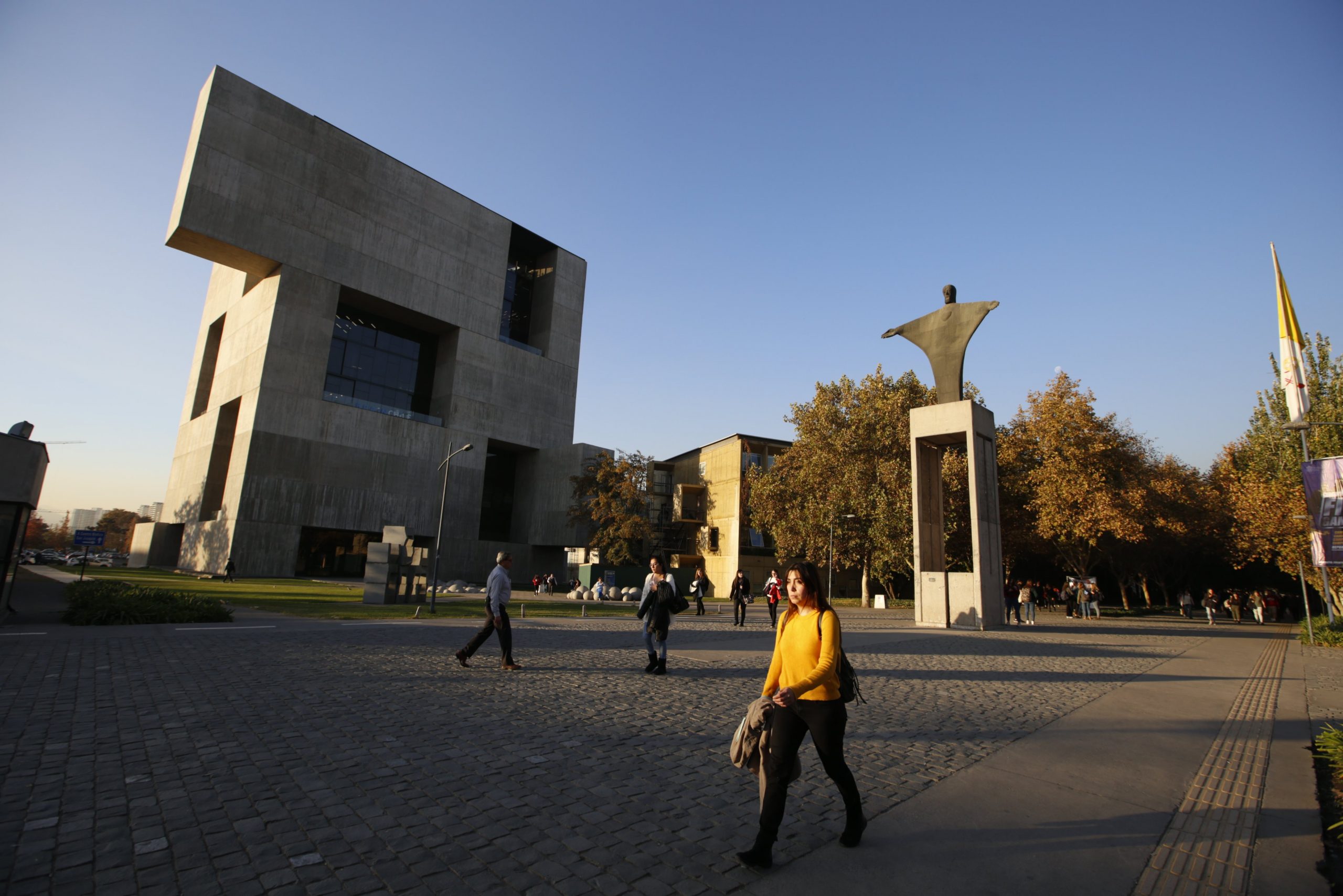 A photo of students walking outside on the campus of UC Chile. 